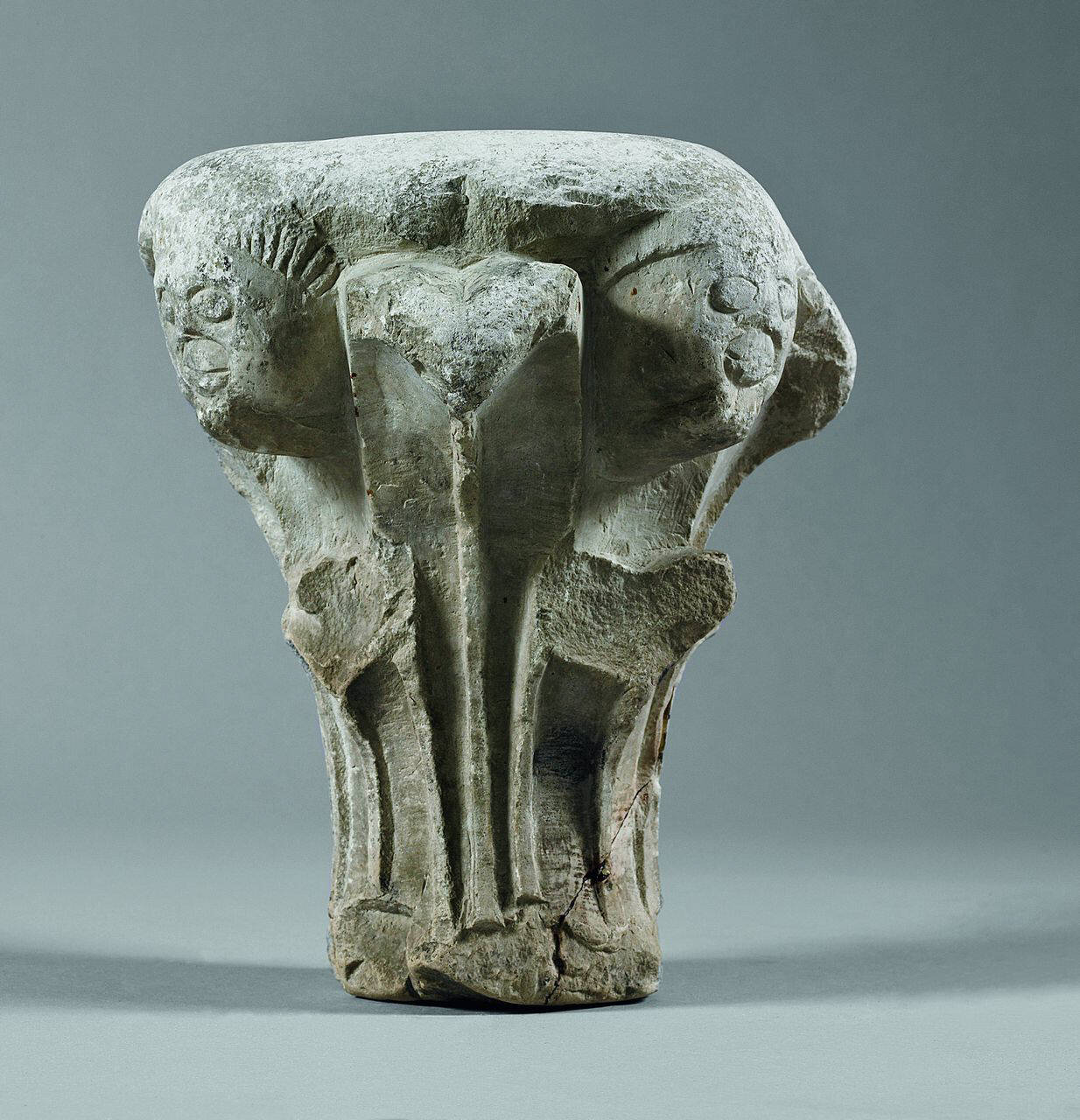 Capitello con quattro protomi umane (capitello) di Scultore - ambito lombardo (sec. XII)